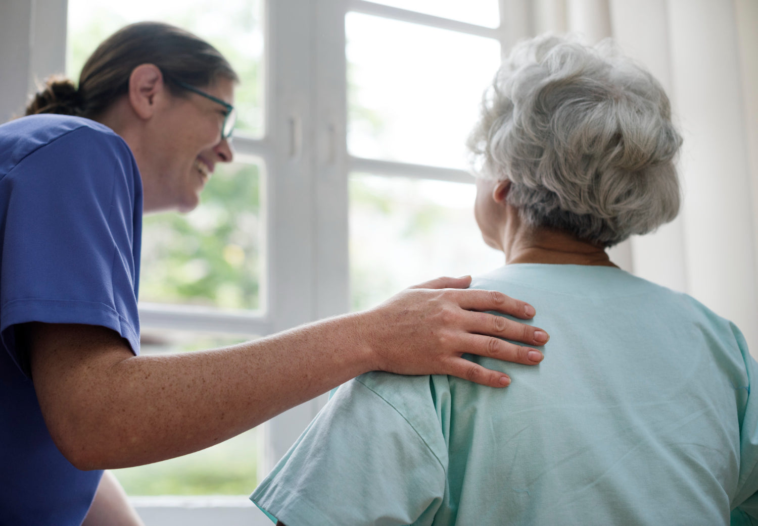 Caregiver comforting an elderly person in a home setting