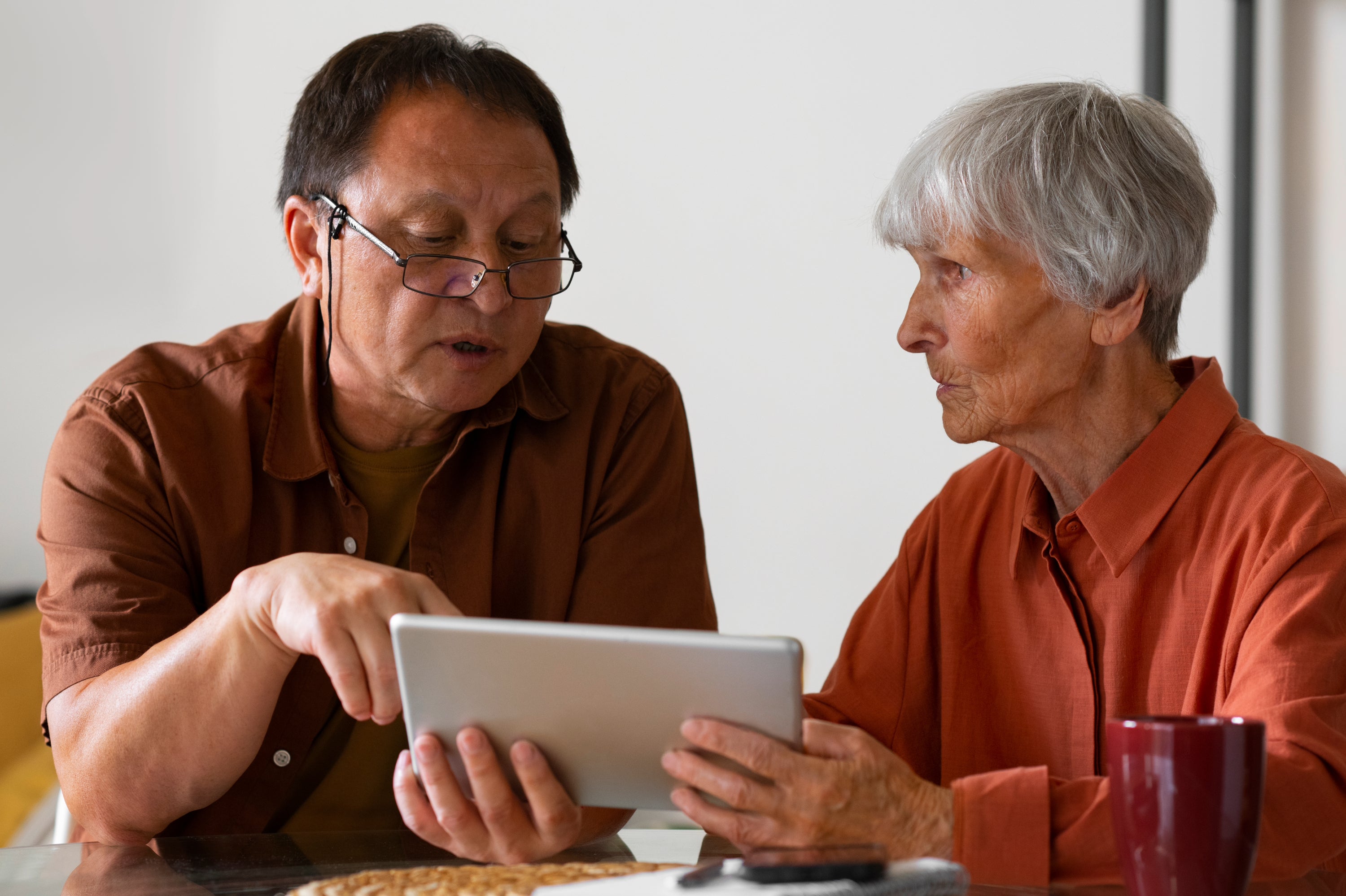 Two older adults looking at the Idem Smart Clock together.