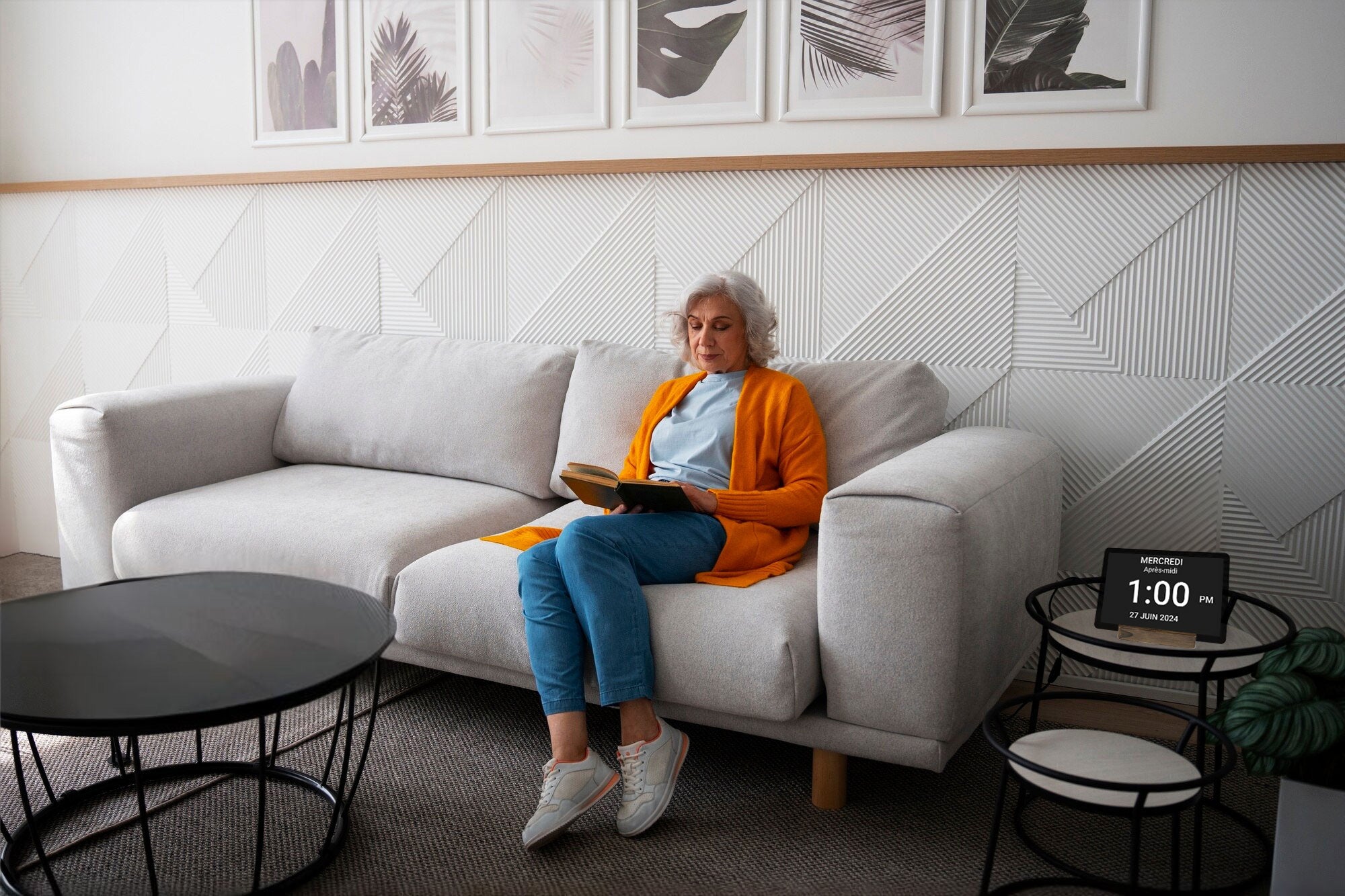 Femme assise sur un divan avec l'horloge Idem à côté d'elle