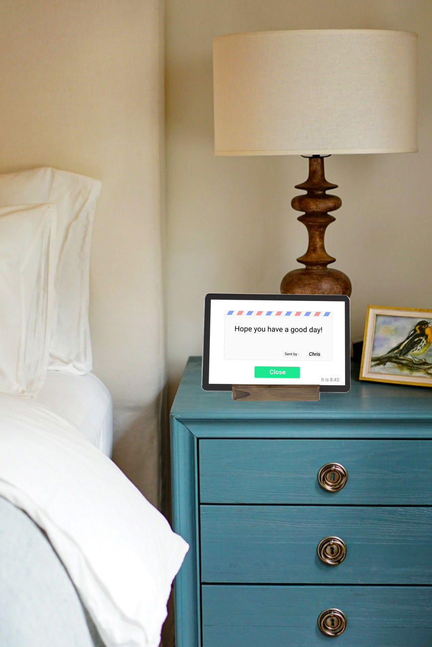 An Idem clock on a bedside table with a message displayed on the clock