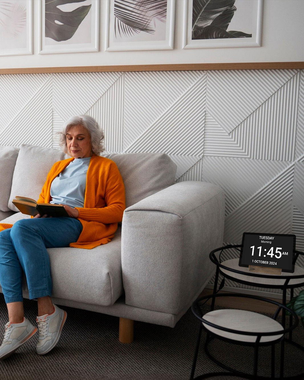 A woman on a couch with the Idem clock next to her reading a book