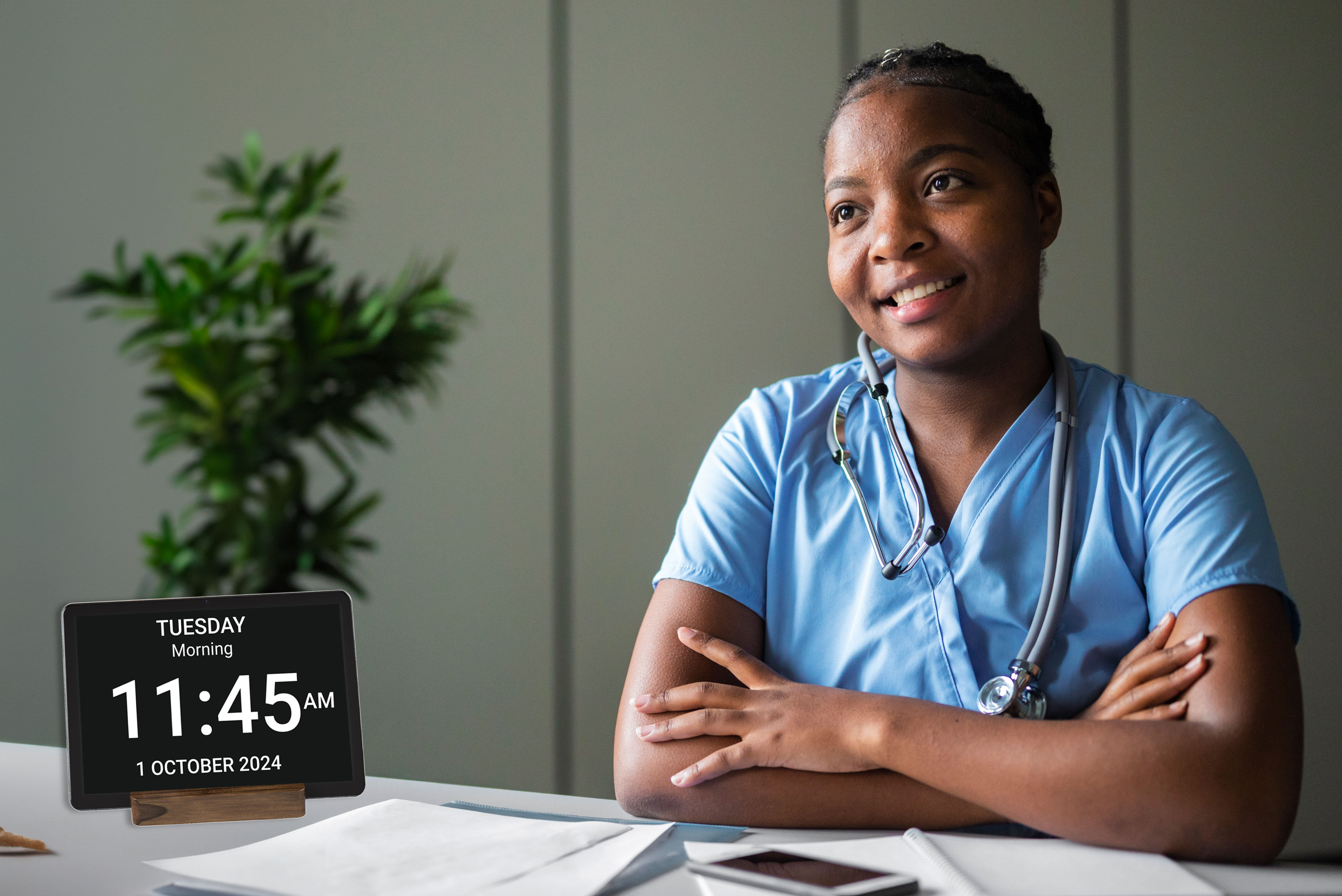 A healthcare professional with the Idem clock on a table in front of her